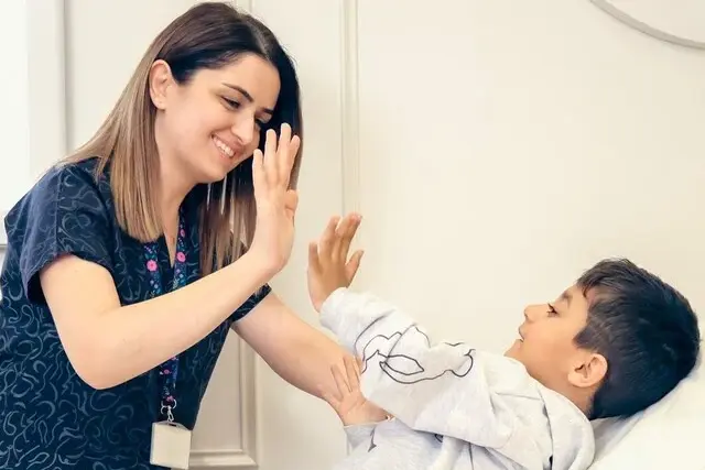 une pédiatre et un enfant se félicite